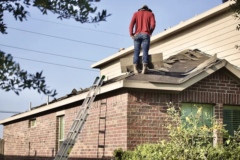 Professional roofer working on a residential roof in East Watertown